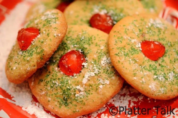 A close up of a couple cherry holiday cookies.