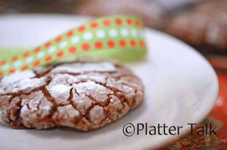 A close up of a fudge crinkle cookie on a plate.