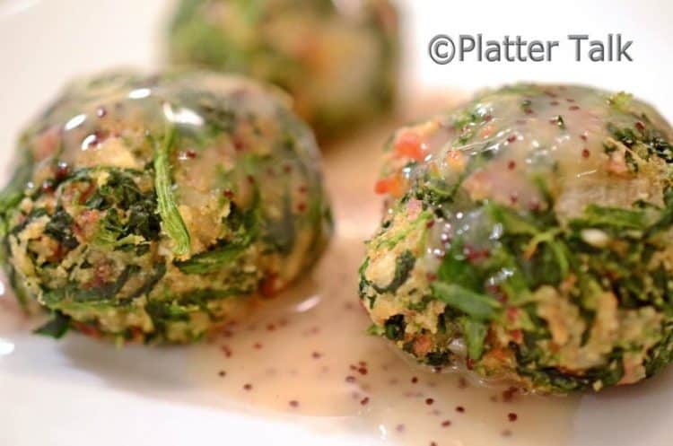 A close up of a bacon spinach ball with dip.