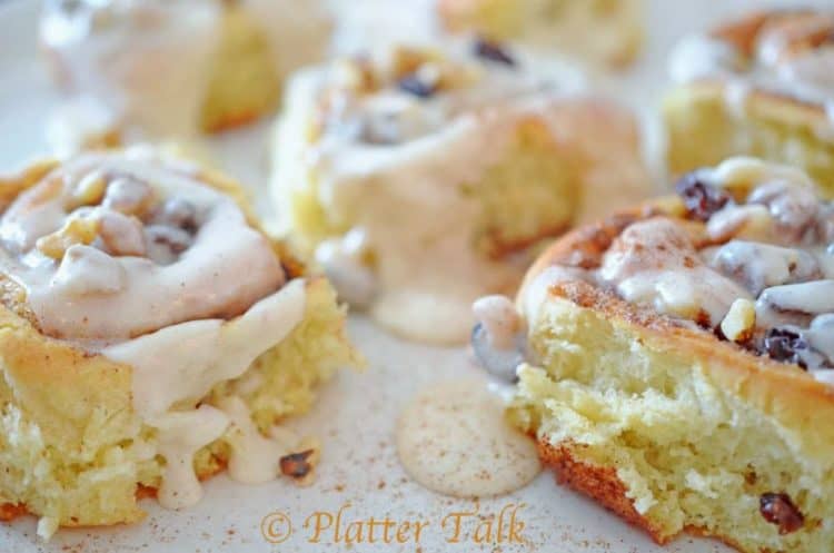 a close up of three cinnamon rolls with icing.