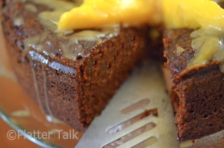 a ginger cake with mango and brandy glaze with a piece taken from it