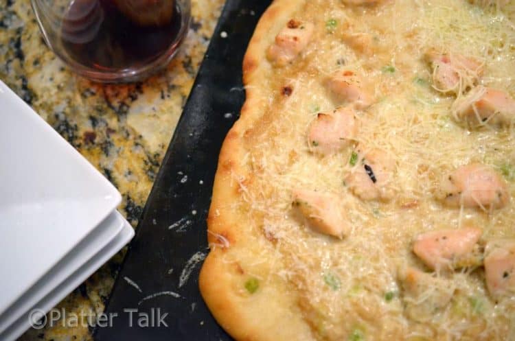 a garlic and ginger chicken pizza on a pizza stone