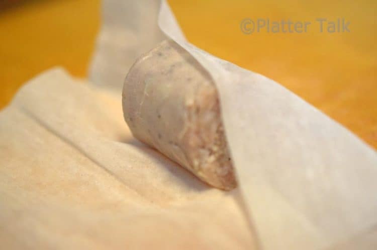 a brat bite getting rolled up in a pastry dough