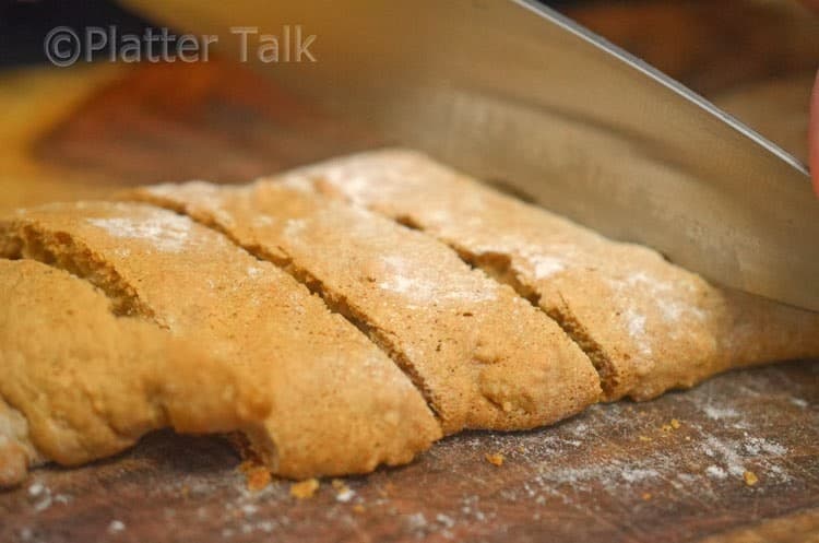 A person cutting the biscotti.