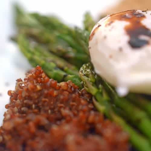 A close up of a Poached Egg over Asparagus and Crispy Quinoa