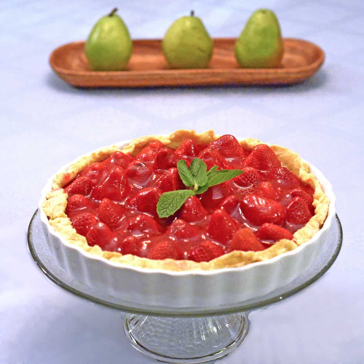 A strawberry pie with basil leaves on top.
