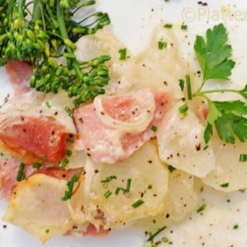 a plate of scalloped potatoes and ham.