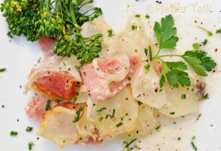 a plate of scalloped potatoes and ham.