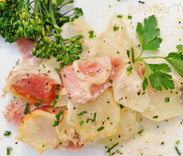 a plate of scalloped potatoes and ham