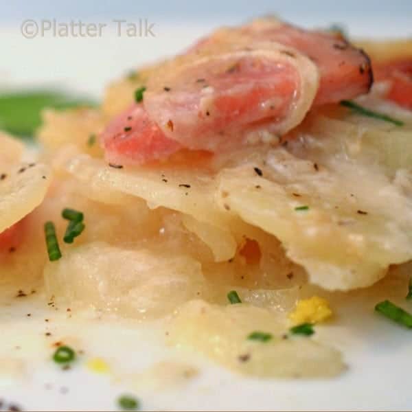 a plate of scalloped potatoes and ham