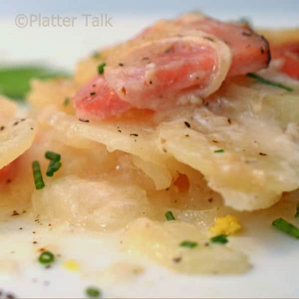 a plate of scalloped potatoes and ham