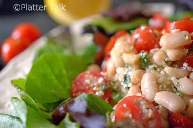 a close up of a white bean cherry tomato salad