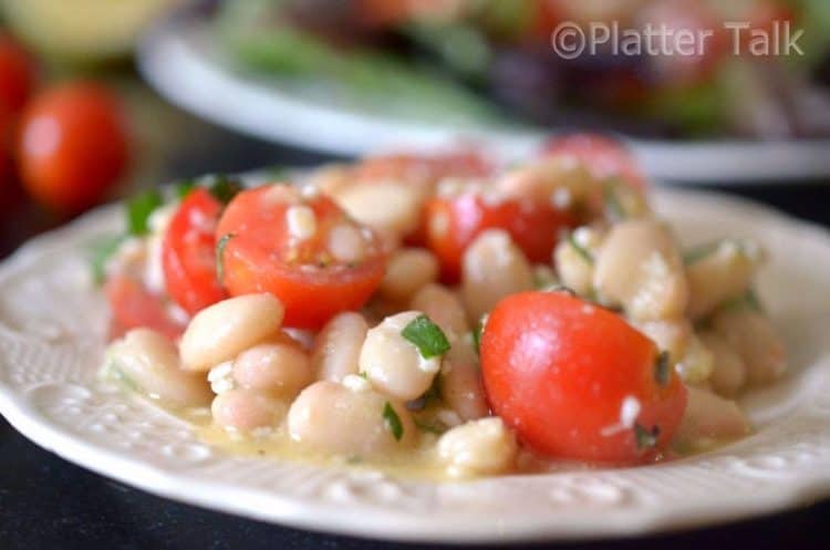 A close-up of tomato salad with white beans.