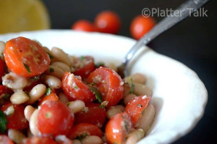 A bowl of tomato salad with white beans.