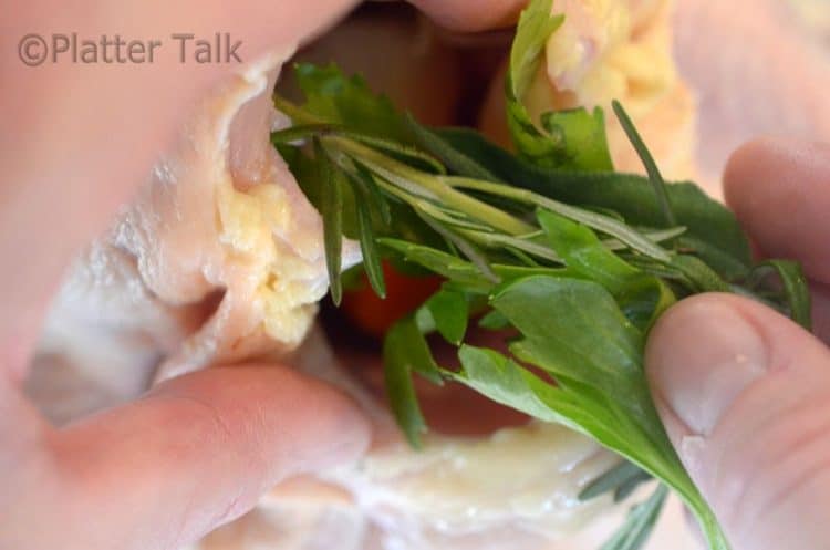 herbs getting put into a chicken