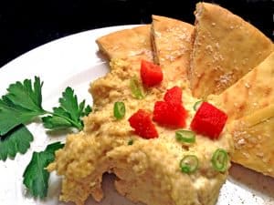 Dish of homemade hummus with toasted pita bread.