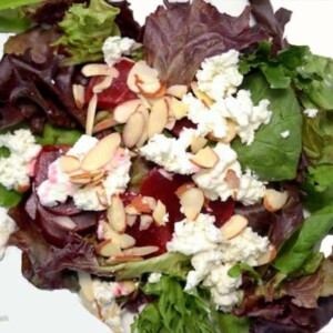 A plate of salad with beets and goat cheese.