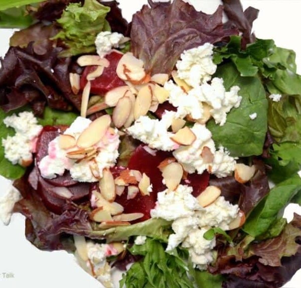 A plate of salad with beets and goat cheese.