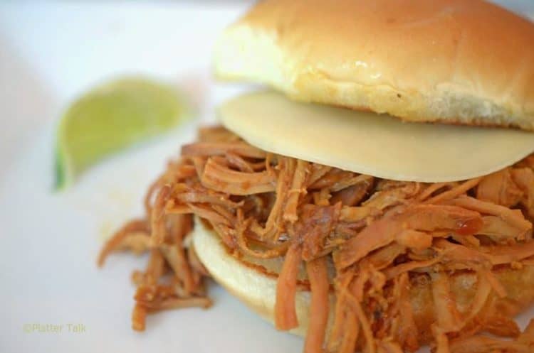 A pulled pork sandwich with cheese.