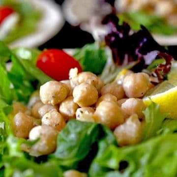 A close up of a plate of salad, with Hummus salad and Chickpea