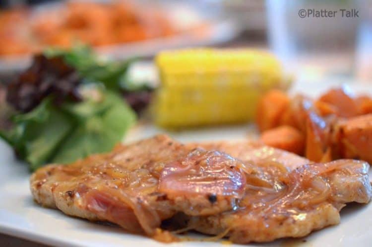 A pork chop on a plate.