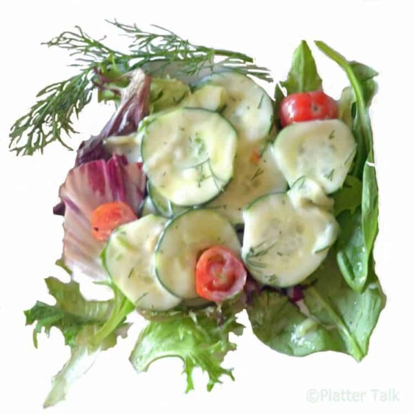 A bowl of cucumber, dill salad.