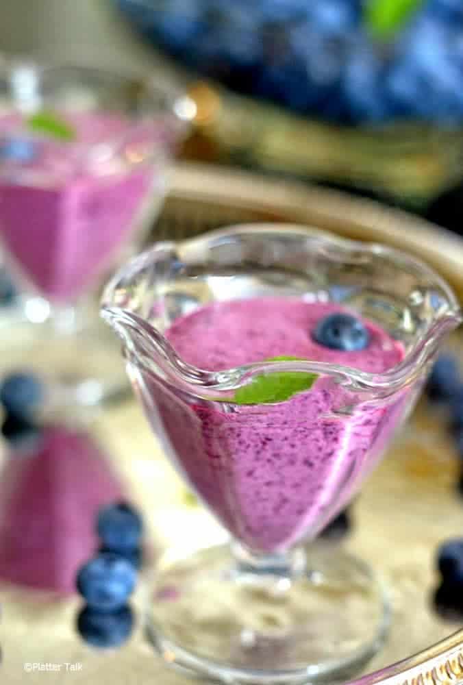 A serving of chilled blueberry soup in a glass dish.