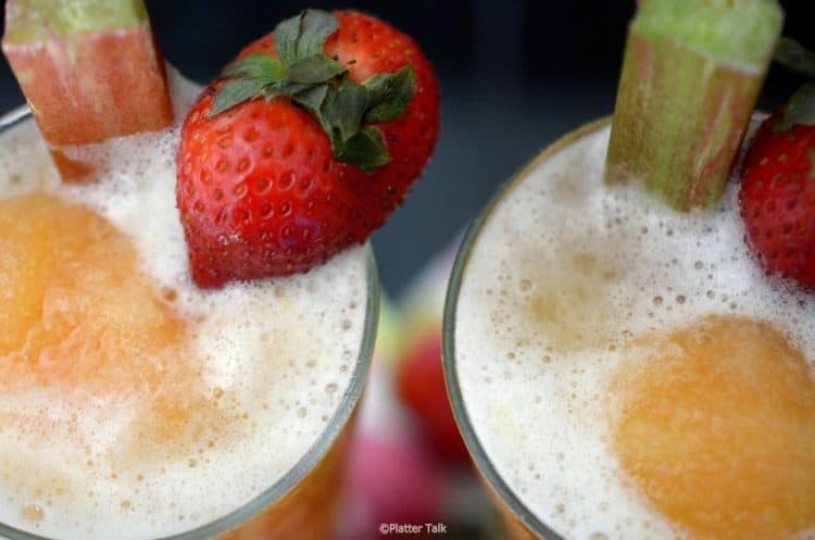 Top view of foamy rhubarb slush, garnished with strawberry and rhubarb in glasses