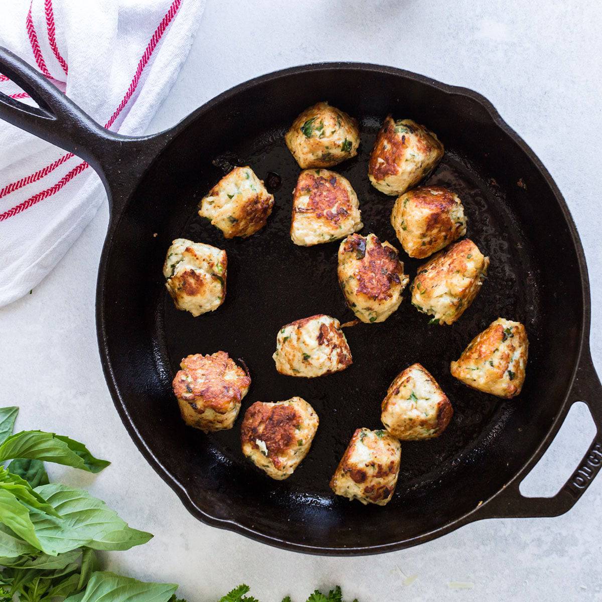 Skillet with browned chicken meatballs