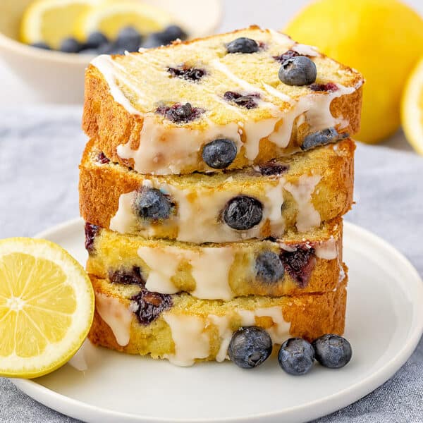 Four slices of lemon and blueberry bread tacked on a plate.