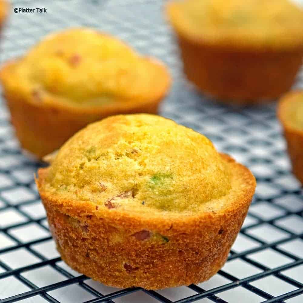 Ham and cheese cornmeal muffins on a cooling rack.