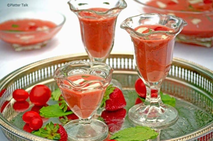 Glasses of gazpacho, sitting on a table.