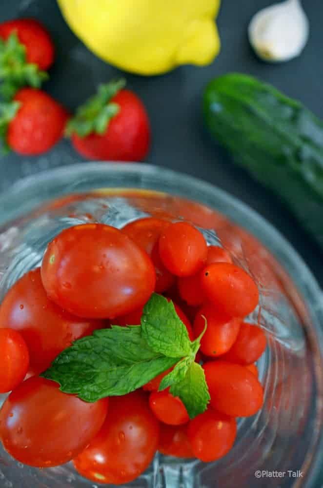 A bowl of tomatoes on a table. 