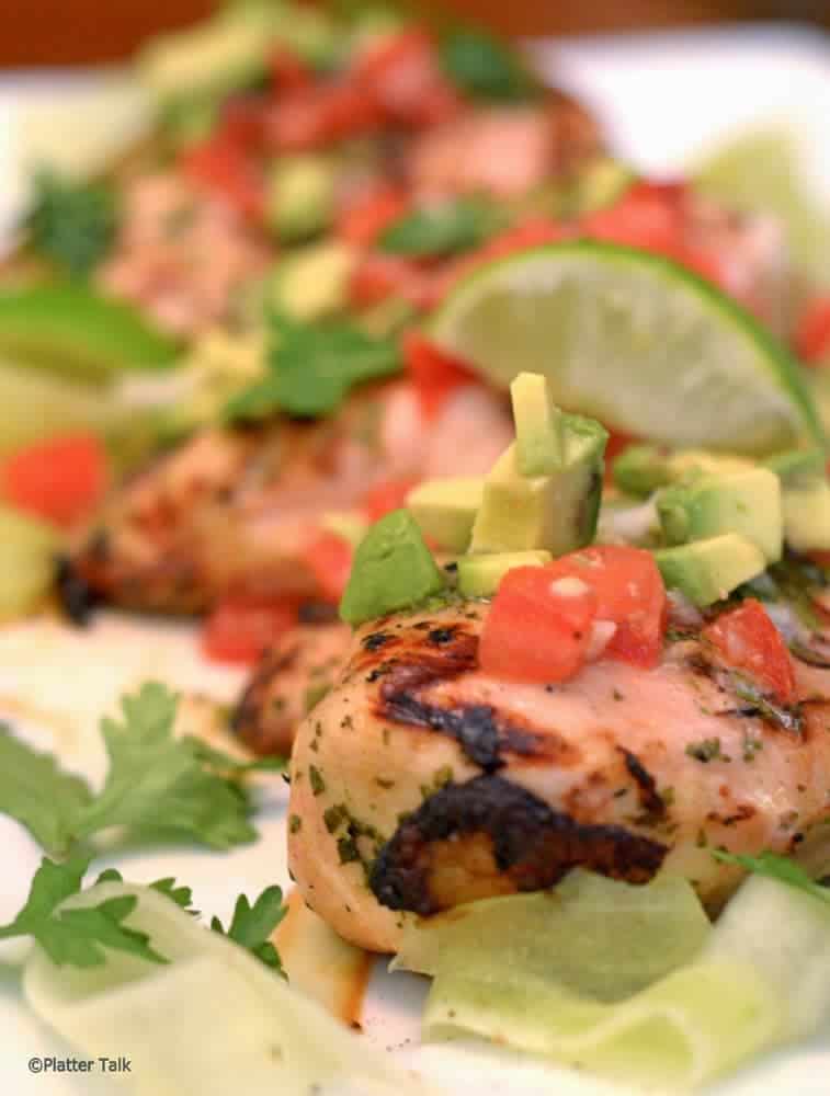 A close-up of a plate of grilled chicken.