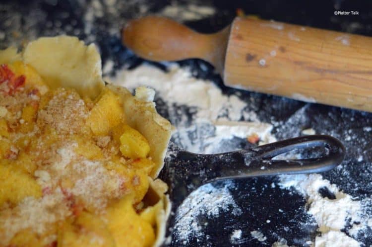 A close-up of an uncooked peach pie.