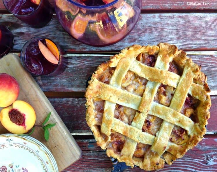 A peach pie on a picnic table.