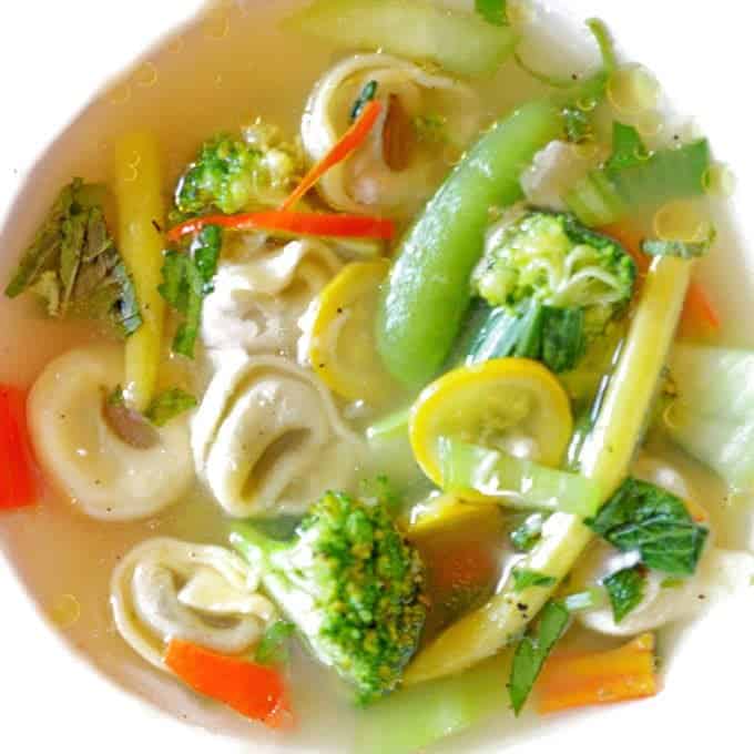 A bowl of soup with Tortellini. 