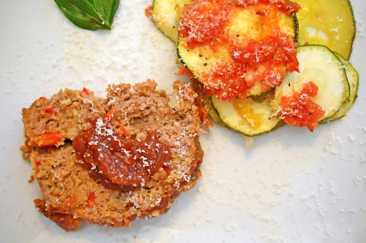 A slice of meatloaf and zucchini on the side