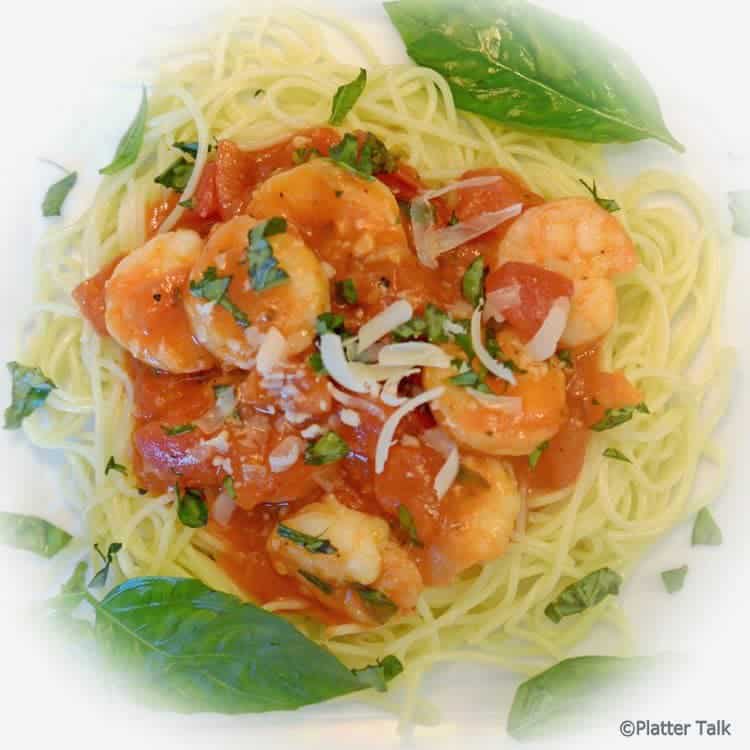 A close up of garlic basil shrimp with pasta.