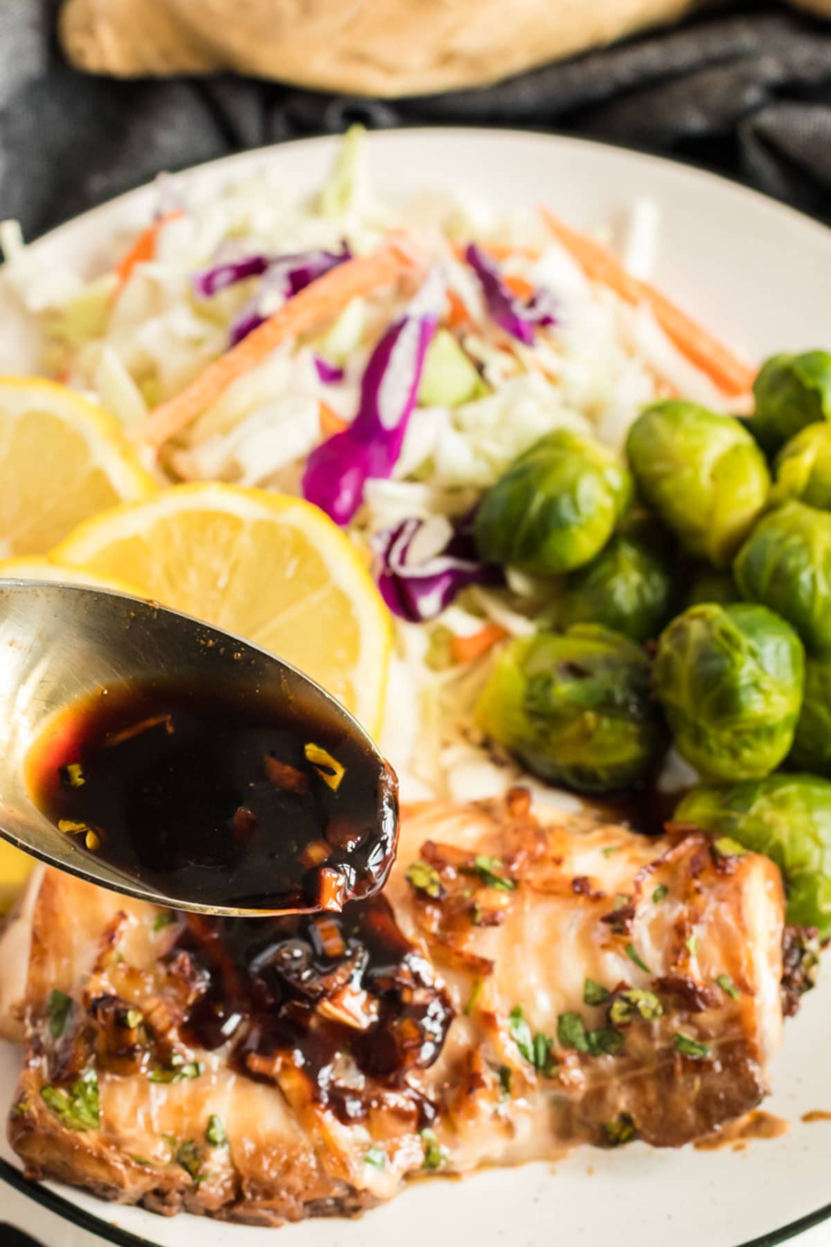 Spooning marinade onto a piece of haddock