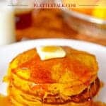 Pumpkin Pancakes stacked on a plate with a pad of butter and dripping syrup.