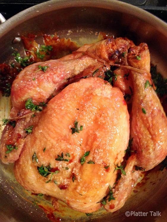 Roasted whole chicken in a pan.