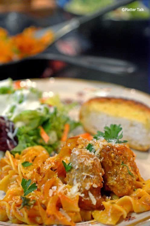 A close-up of a plate of sausage and noodles.