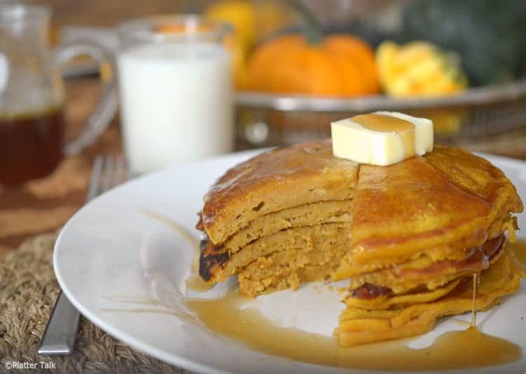 Plate of pumpkin pancakes with butter and syrup.