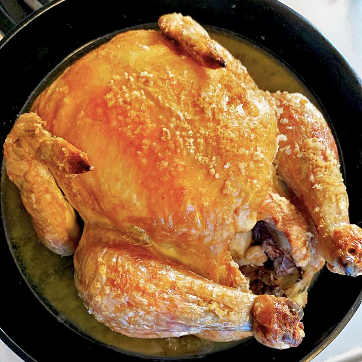 Whole roasted chicken in a skillet