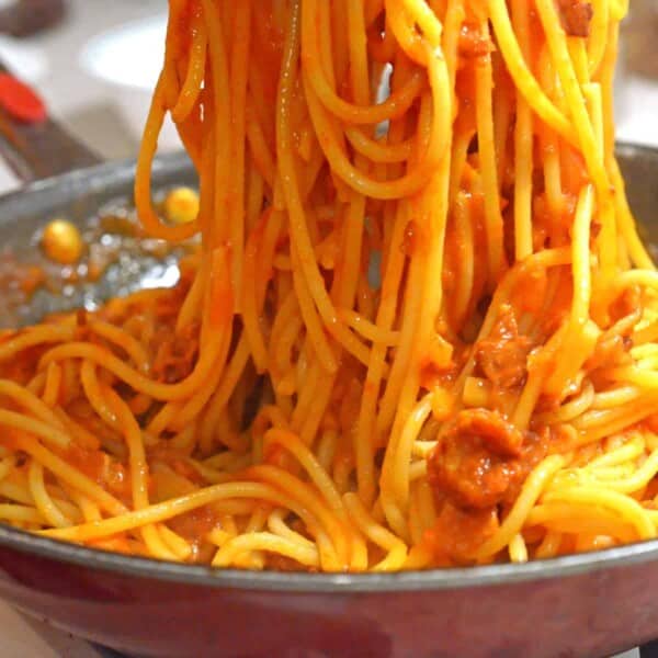 A bunch of spaghetti with sauce in a pan.