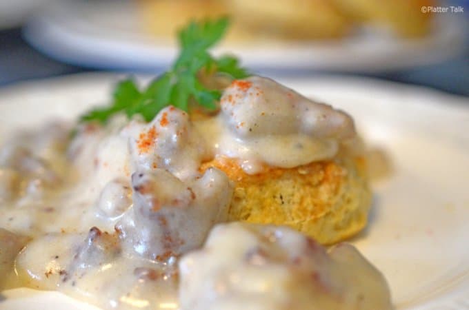 A close up of a plate of food, with Gravy and Biscuit