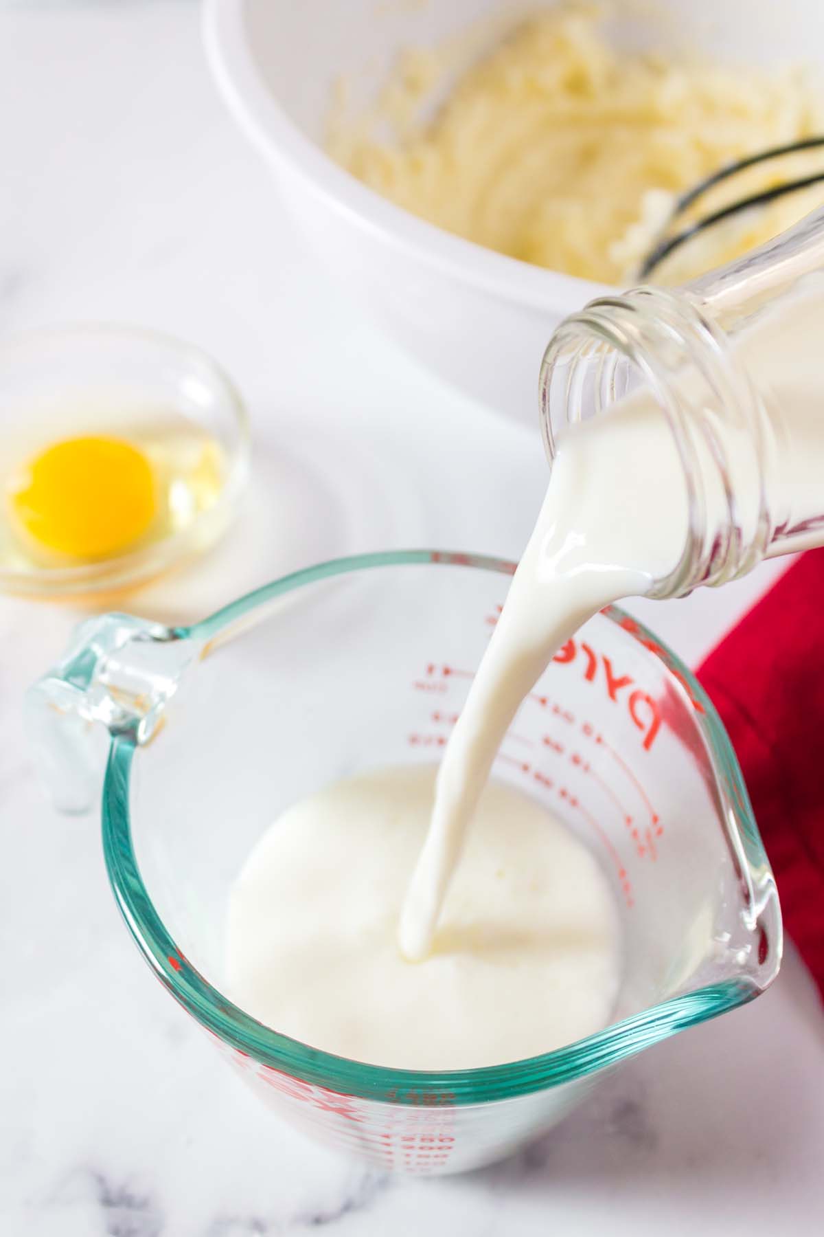 Adding milk to a measuring cup.