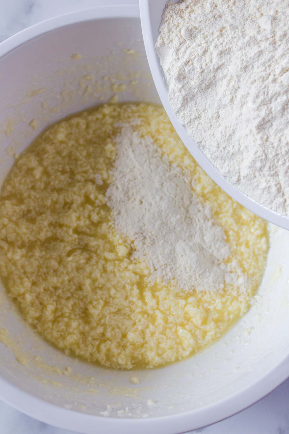 Adding flour to an egg and butter mixture.