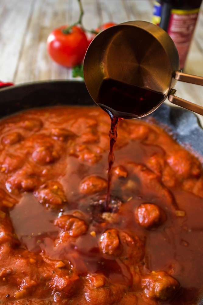 Red wine being added to lasagana sauce.